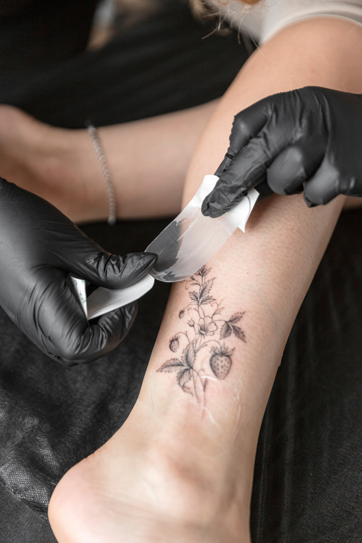 Professional tattoo artist tattooing a woman at tattoo studio